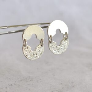 Aros de plata artesanales modelo Entreluz, diseño circular con detalle grabado floral y corte central en forma de cruz